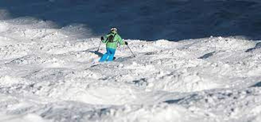 A person is skiing down a snow covered slope.