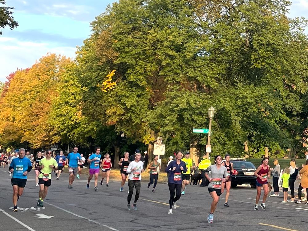 A group of people are running a marathon on a city street.