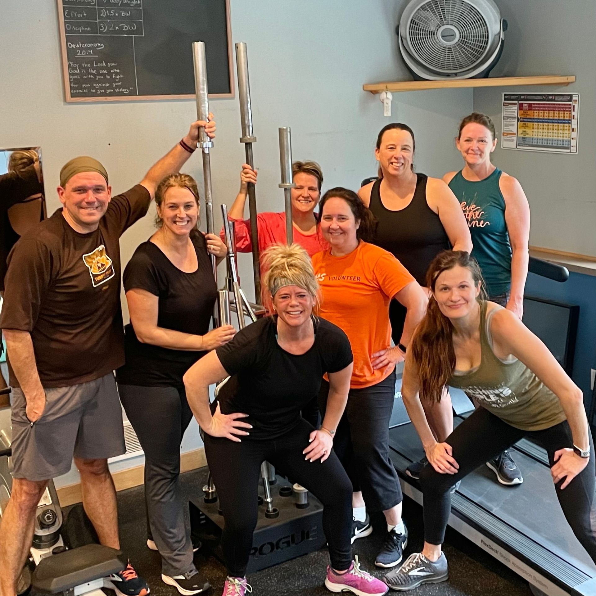 A group of people are posing for a picture in a gym