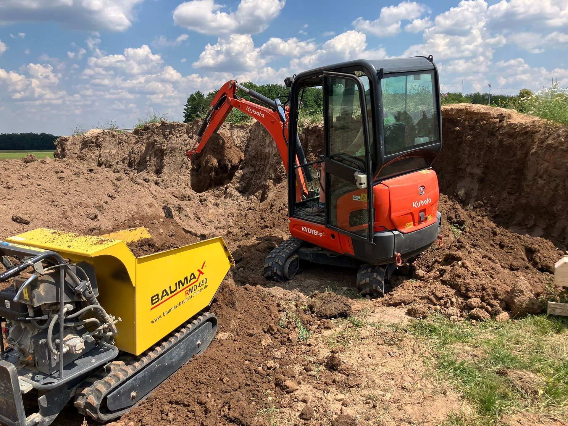 Auffahrt zur Garage wird mit einem Minibagger mit Kies befüllt. Die Rabatten sind schon gesetzt
