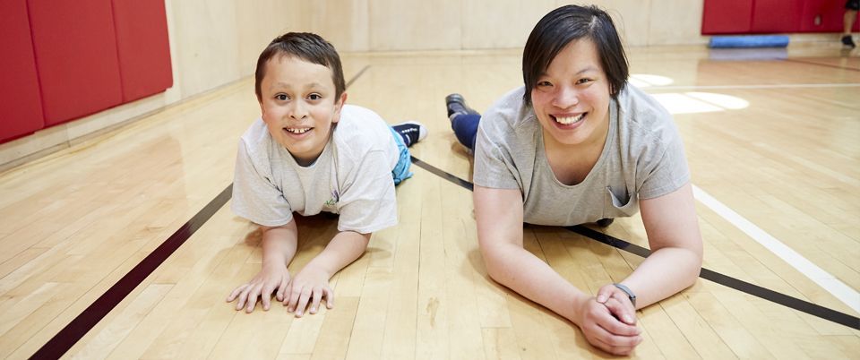 KEEN Athlete and Volunteer Lying on Gym Floor Smiling