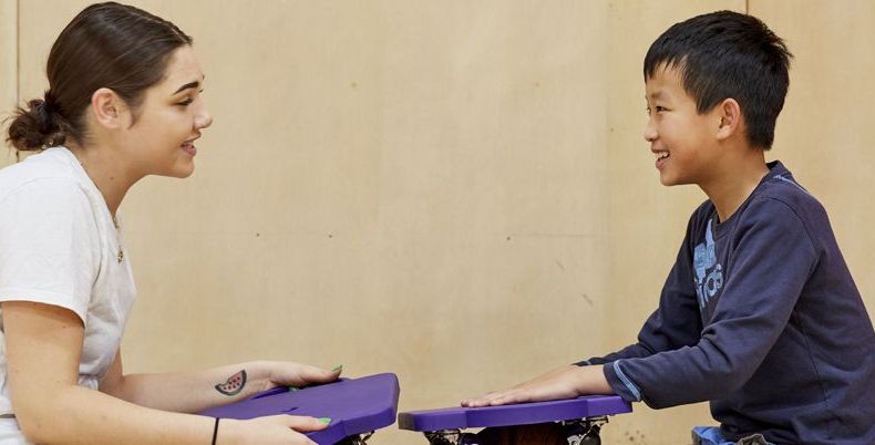 KEEEN Volunteer and Athlete Sitting on gym floor