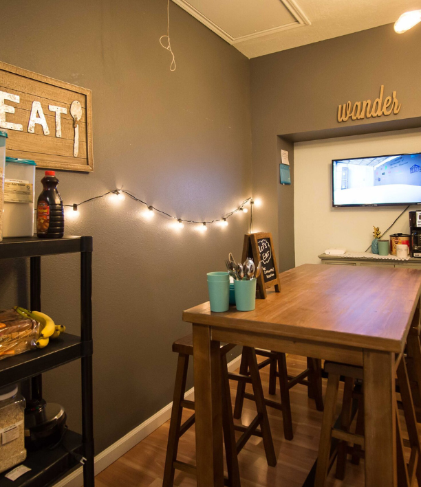Small dining area with table, stools, wall decor, and a small TV.
