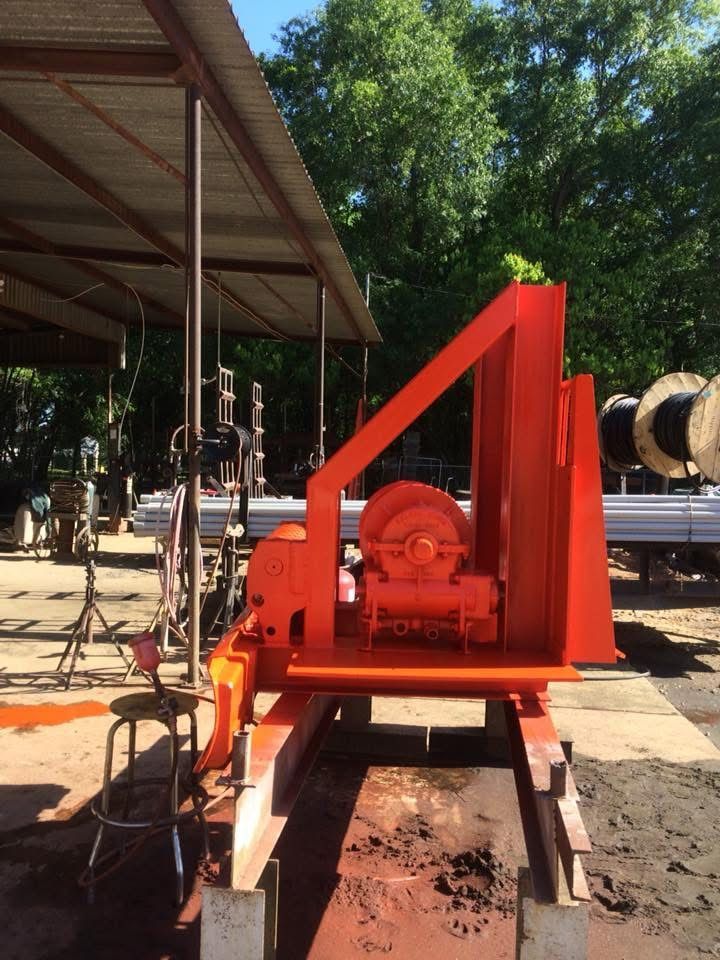 A large orange machine is sitting under a covered area