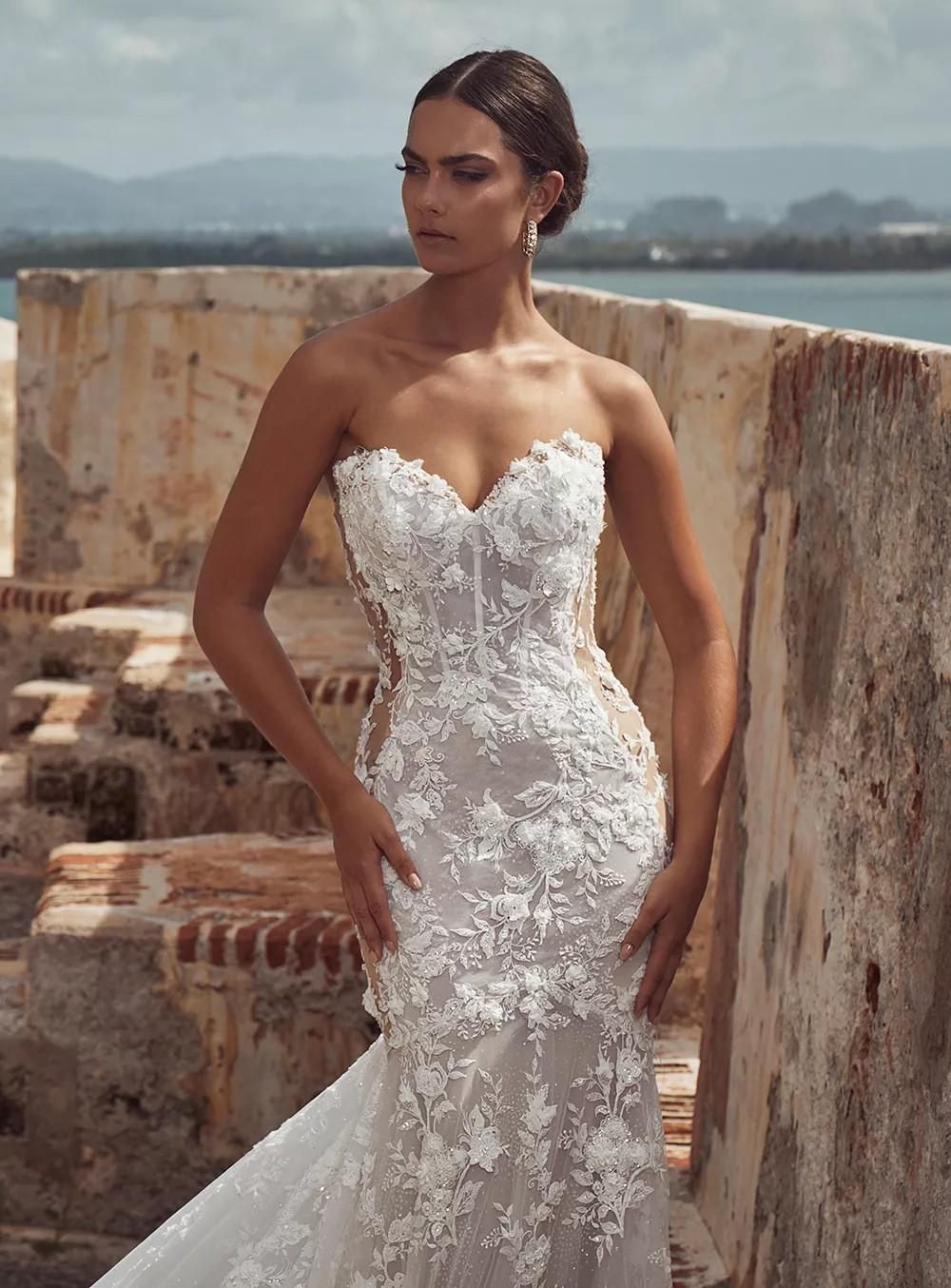 A woman in a wedding dress is standing next to a wall.