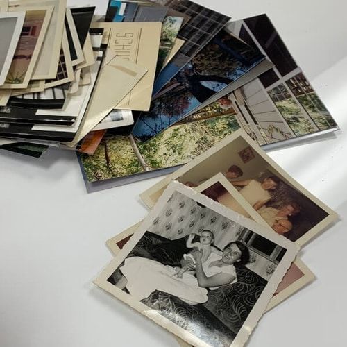 une pile de photos anciennes est assise sur une table .