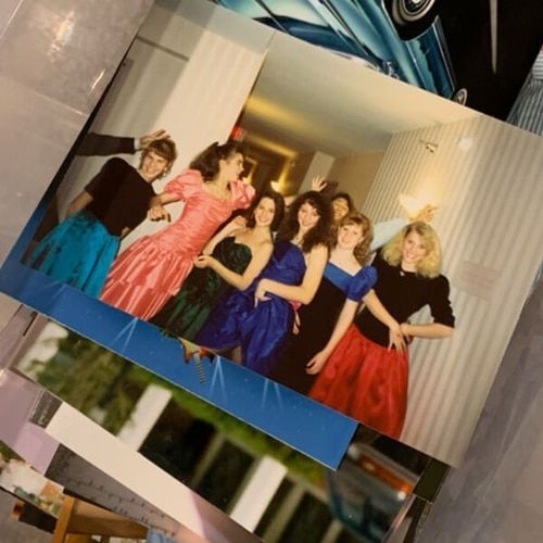 un groupe de femmes vêtues de robes de bal se tiennent l' une à côté de l' autre .