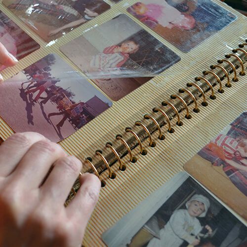 une personne ouvre un album photo avec beaucoup de photos .