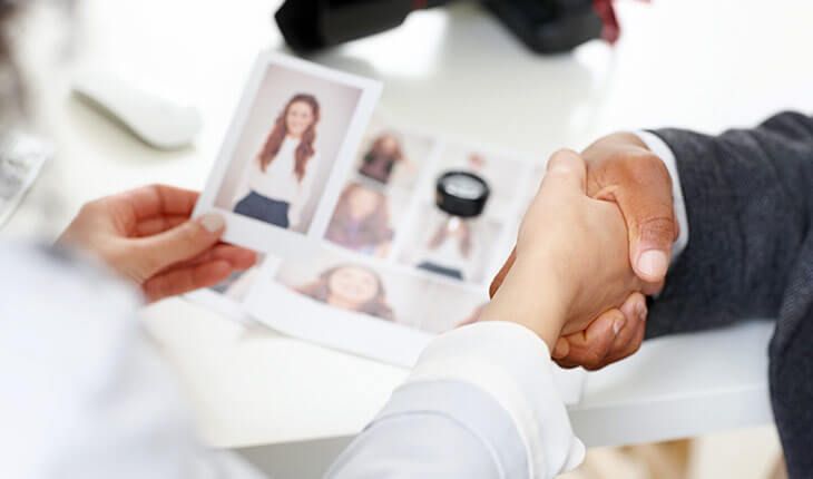 a man and a woman are shaking hands over a picture of a woman .