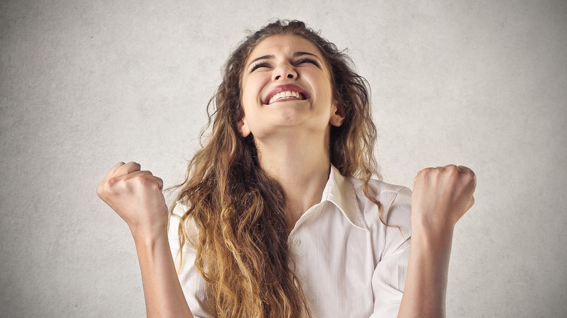 a woman with her fist in the air is smiling