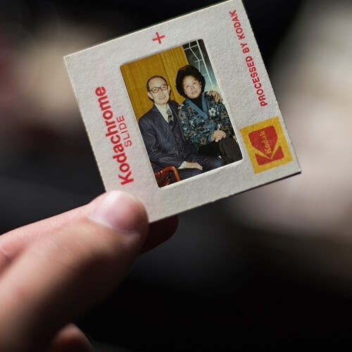une personne tient un diapositive kodachrome avec une photo d' un homme et d' une femme .