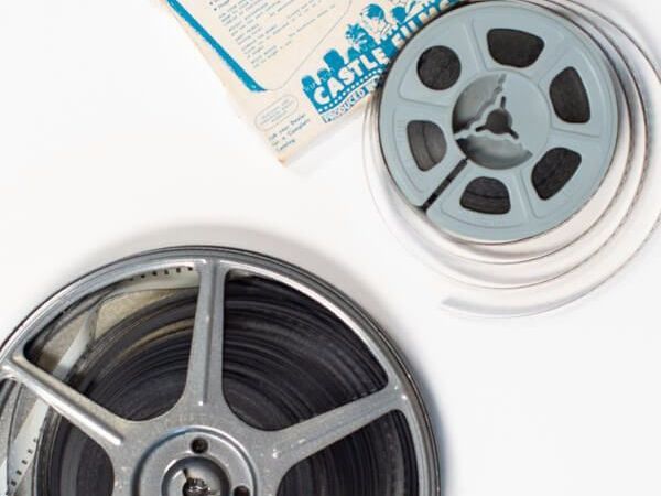 two reels of film are sitting next to each other on a white surface .