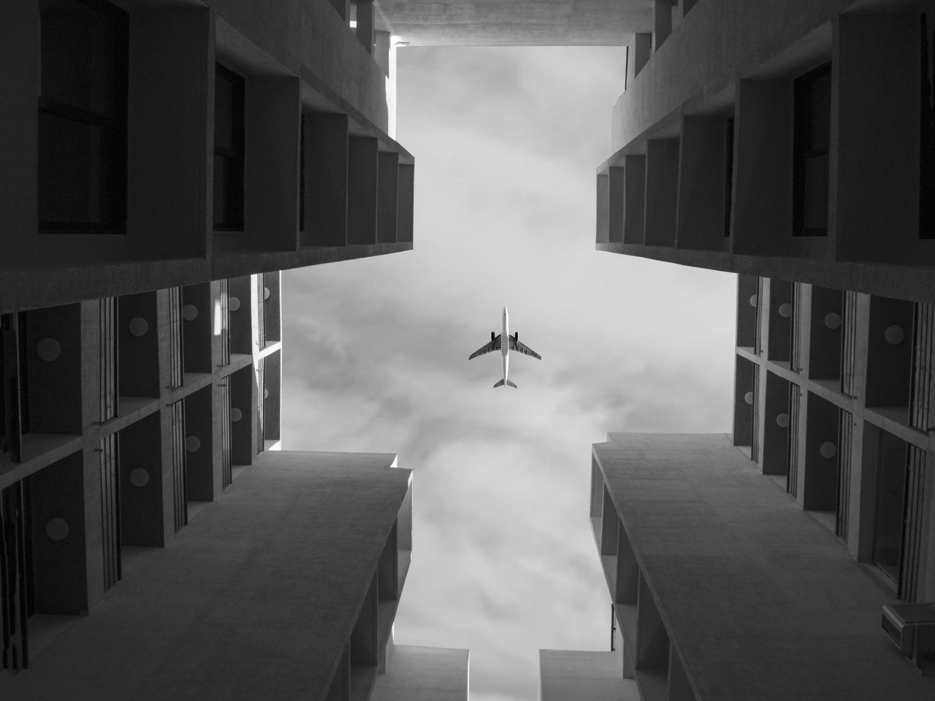 a plane is flying through the air between two buildings