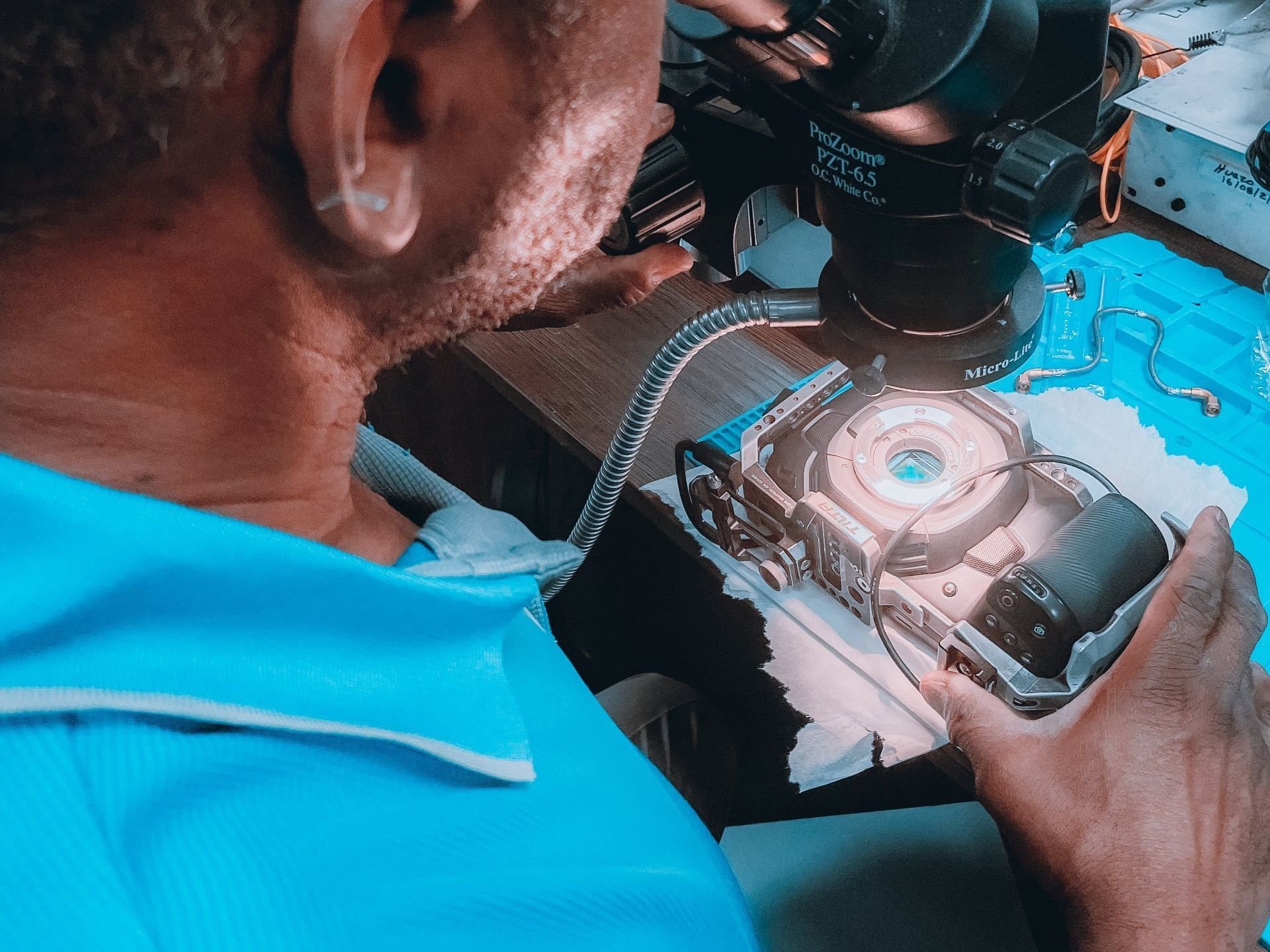 un homme regarde à travers un microscope avec un objectif de 1x