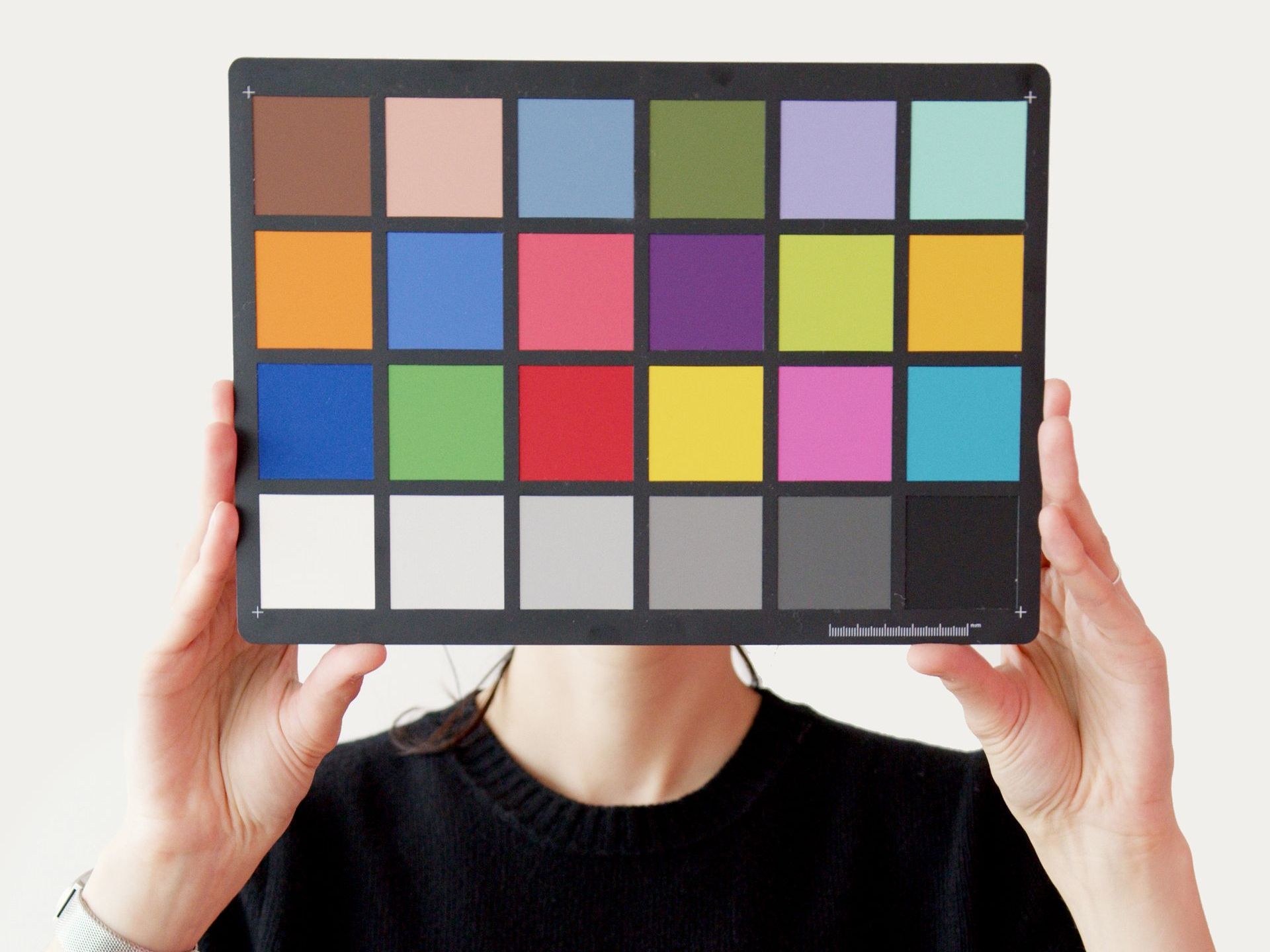 a woman is holding a color palette in front of her face