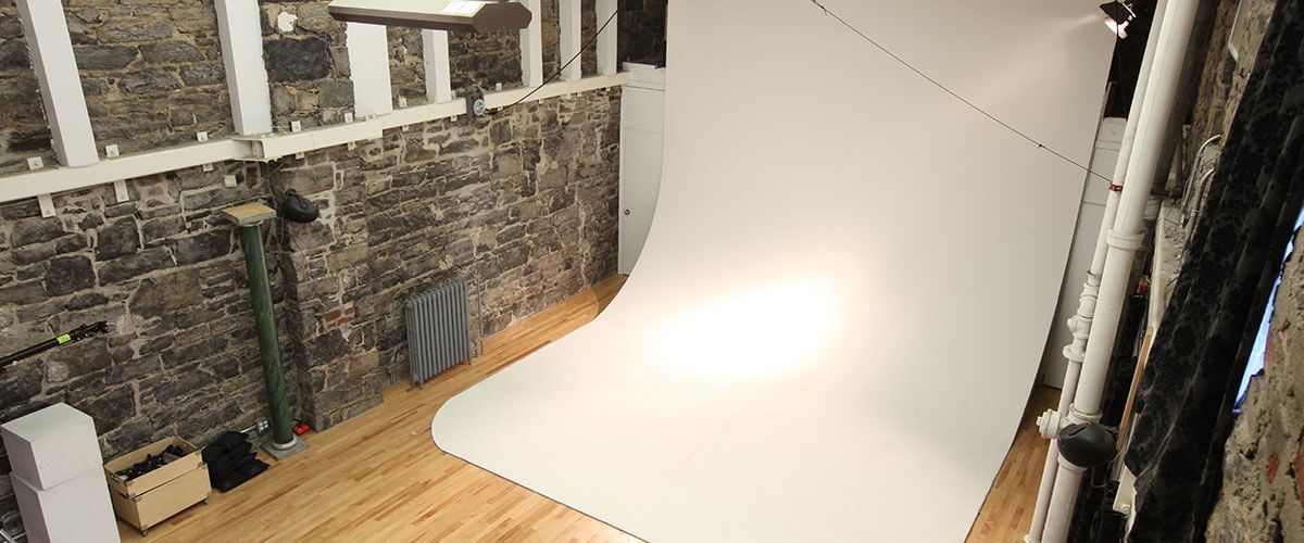 un studio photo avec un mur en pierre et un plancher en bois