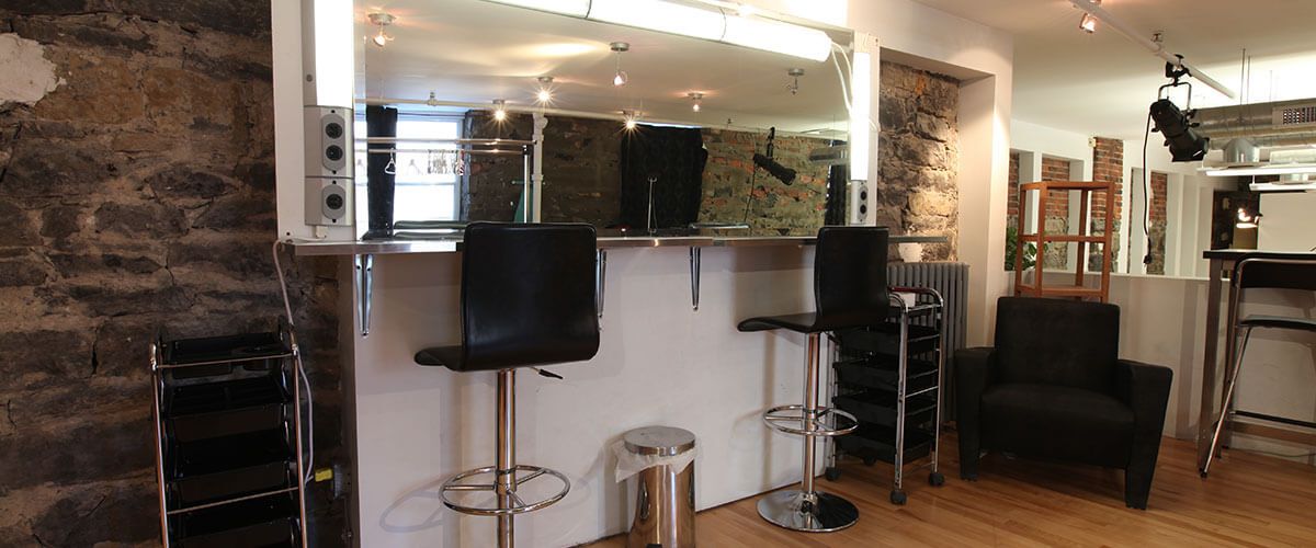 two bar stools are in front of a mirror in a salon