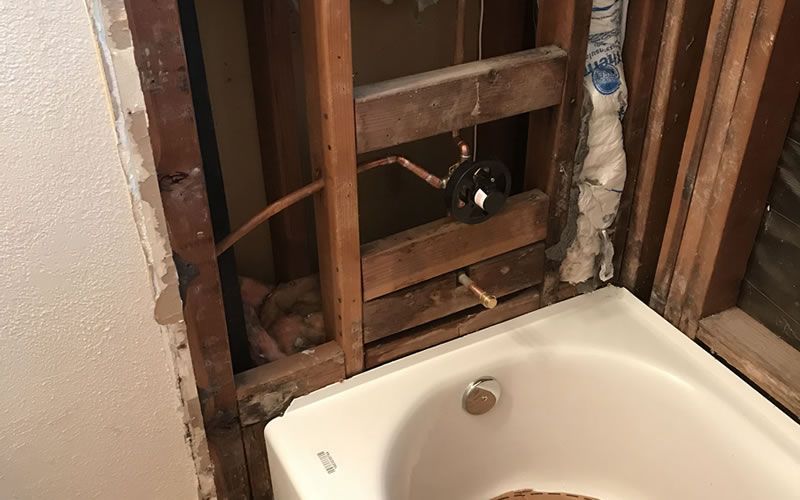 a bathroom with a bathtub and a wall that has been removed