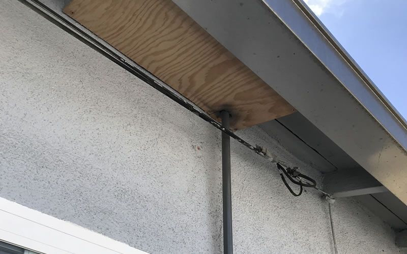 a white wall with a wooden plank on top of it