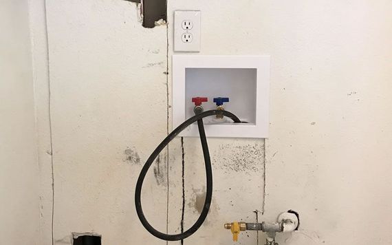 a hose is connected to a washer and dryer outlet