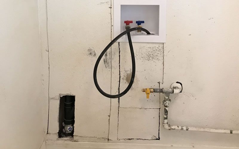 a hose is connected to a washer and dryer