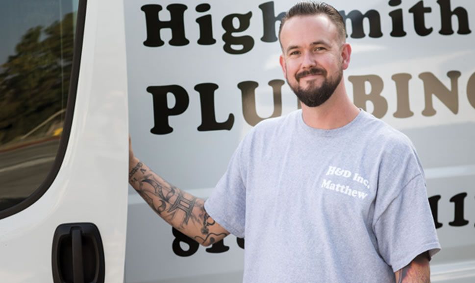 a man standing in front of a van that says highsmith plumbing