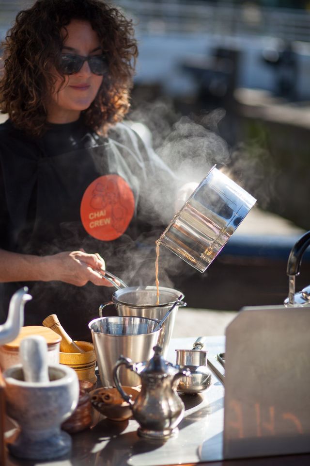 A woman is pouring hot liquid into a pot.