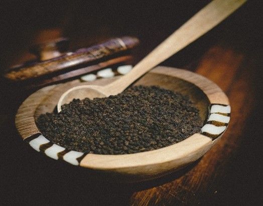 A bowl of dirt with a wooden spoon in it