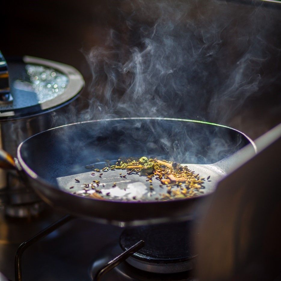 Smoke is coming out of a frying pan on a stove