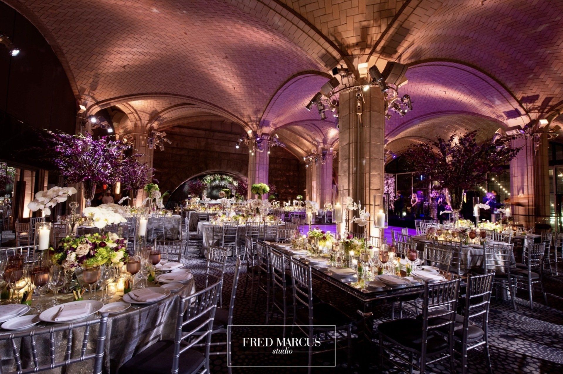 A large room with tables and chairs set up for a wedding reception.