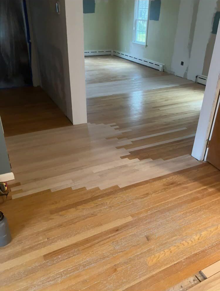 A large empty dance studio with a wooden floor and mirrors.