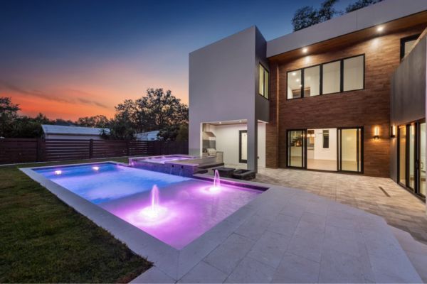 A large house with a large swimming pool in front of it