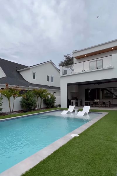 A large white house with a swimming pool in front of it