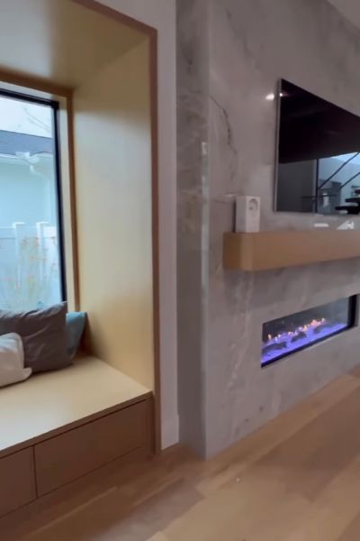 A living room with a fireplace and a window seat.