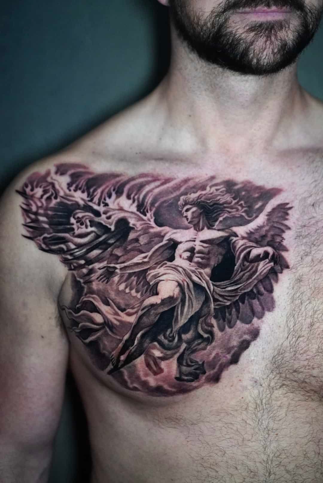 Man's chest tattoo: angel with wings battling a dragon, shaded in grayscale.