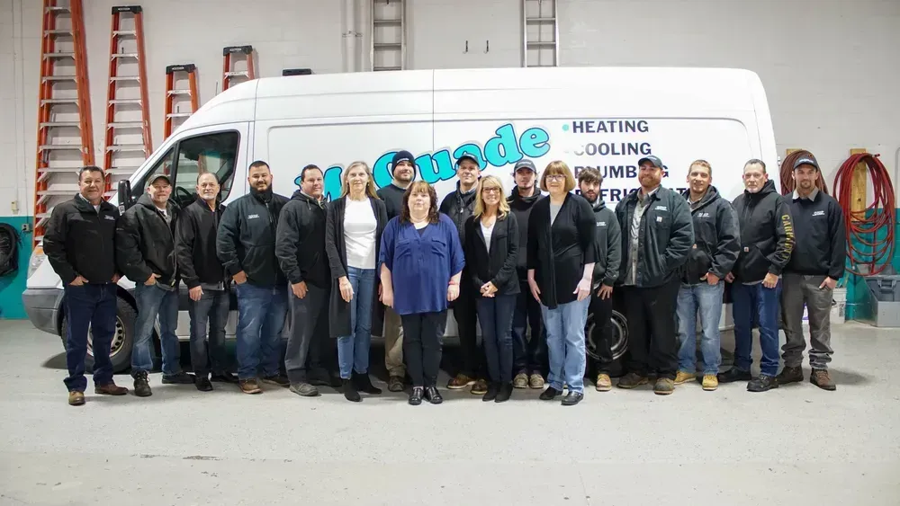 A group of people are posing for a picture in front of a van.
