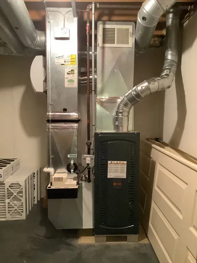 A basement with a heater and air conditioner in it.