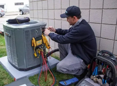 A worker is checking an outdoor AC unit.