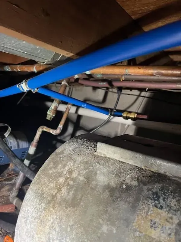 A bunch of pipes are hanging from the ceiling of a building.