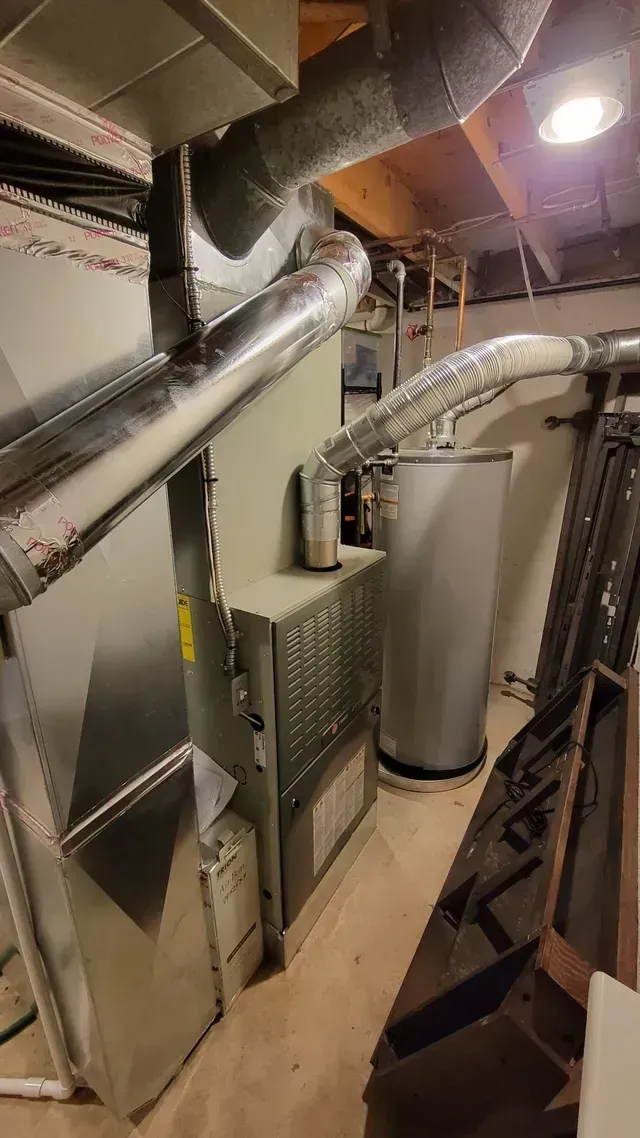 A room with a heater and a water heater in it.