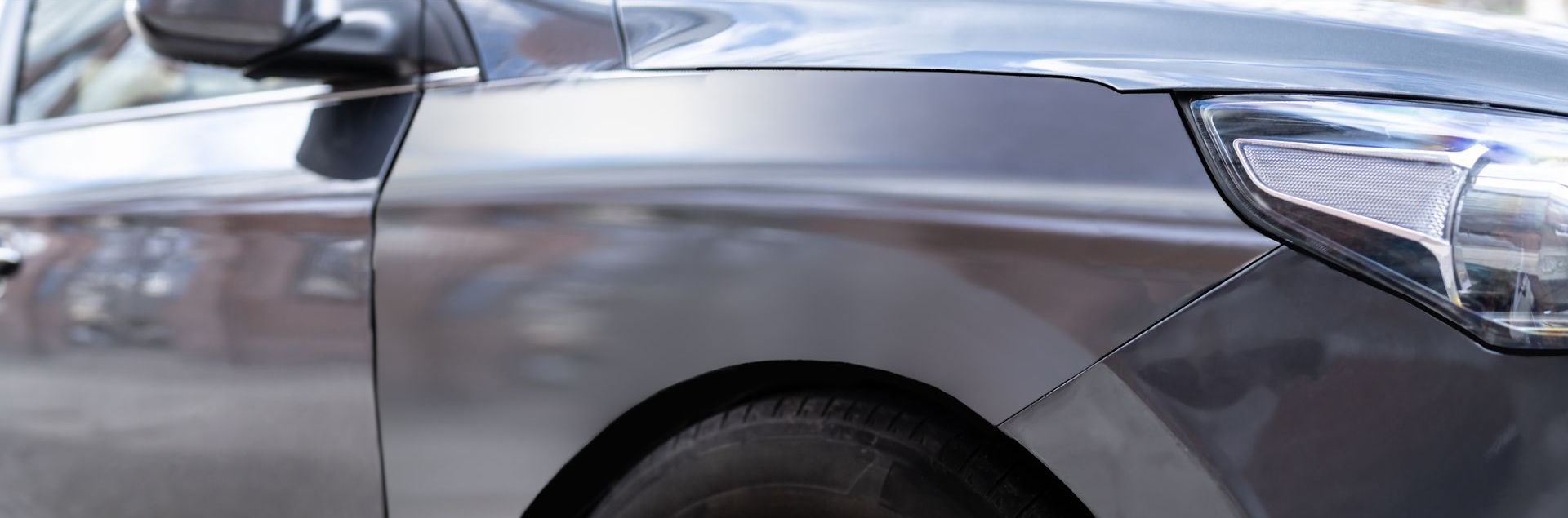 A close up of a car 's fender and headlight.