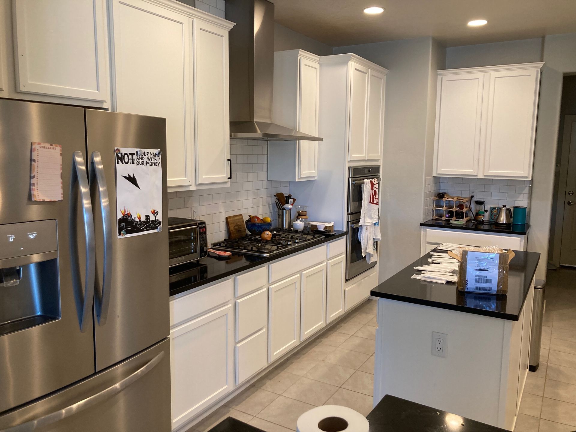A kitchen with white cabinets and stainless steel appliances.