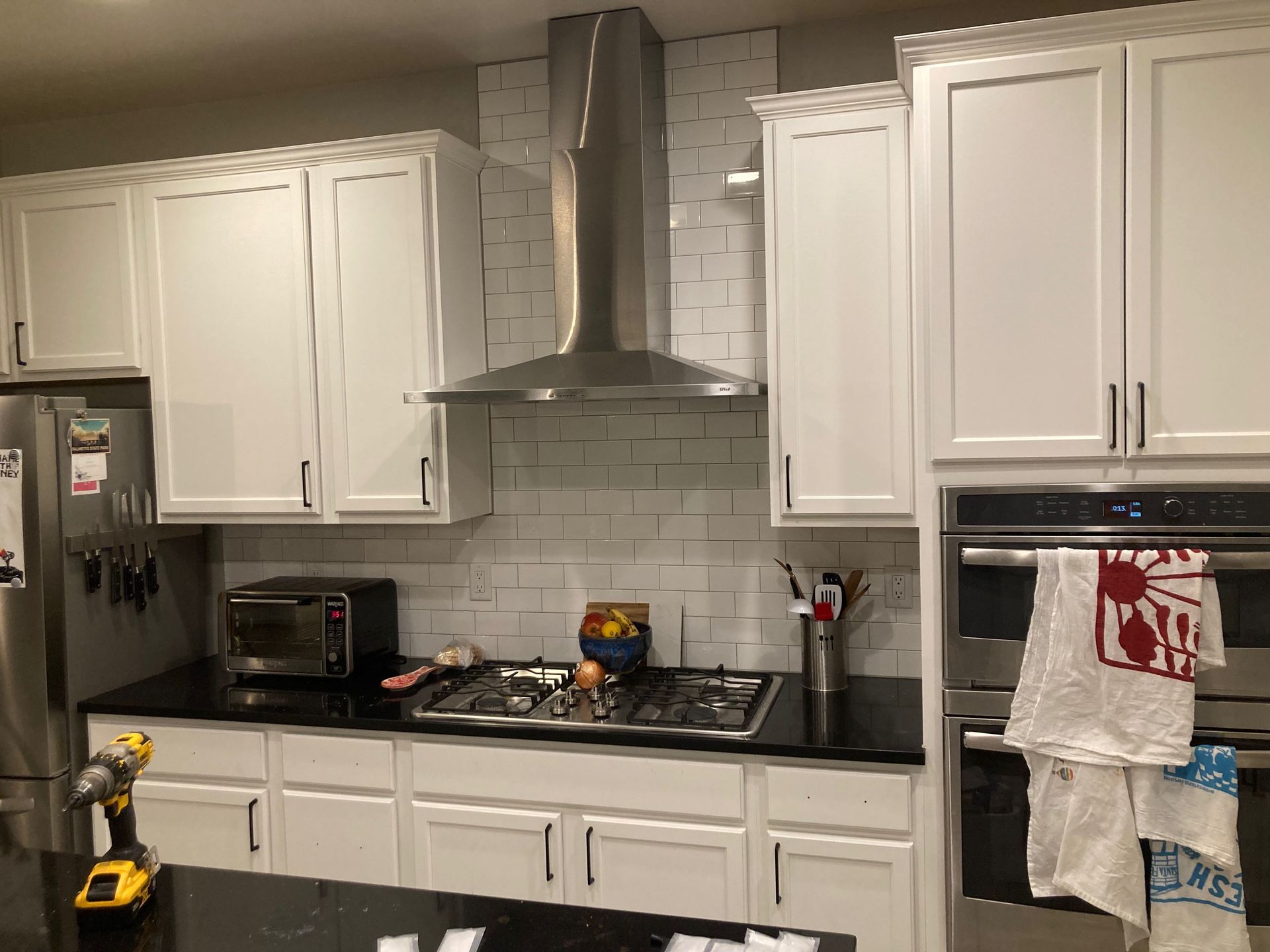 A kitchen with white cabinets and stainless steel appliances.