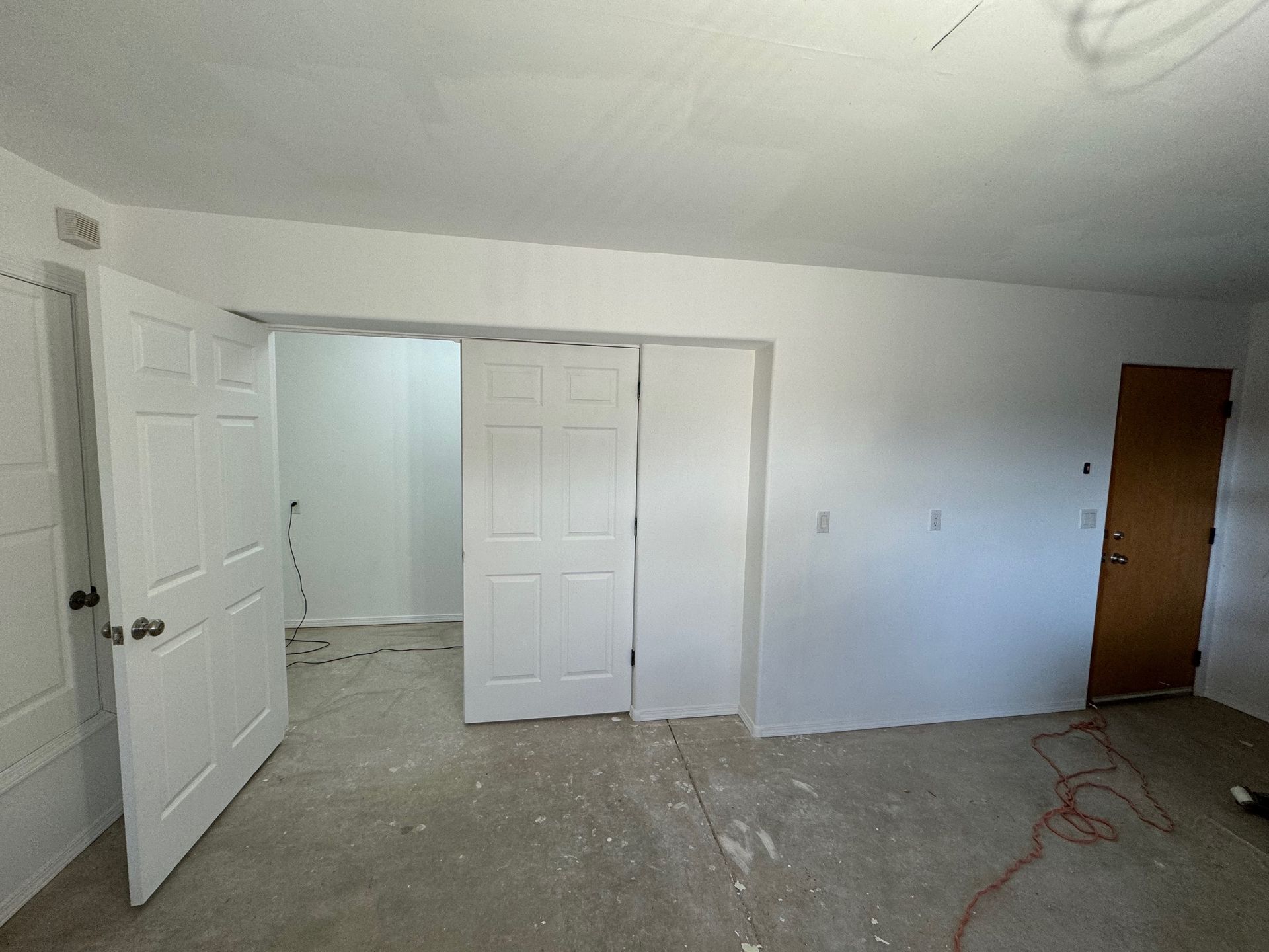 An empty room with white walls and a wooden door.