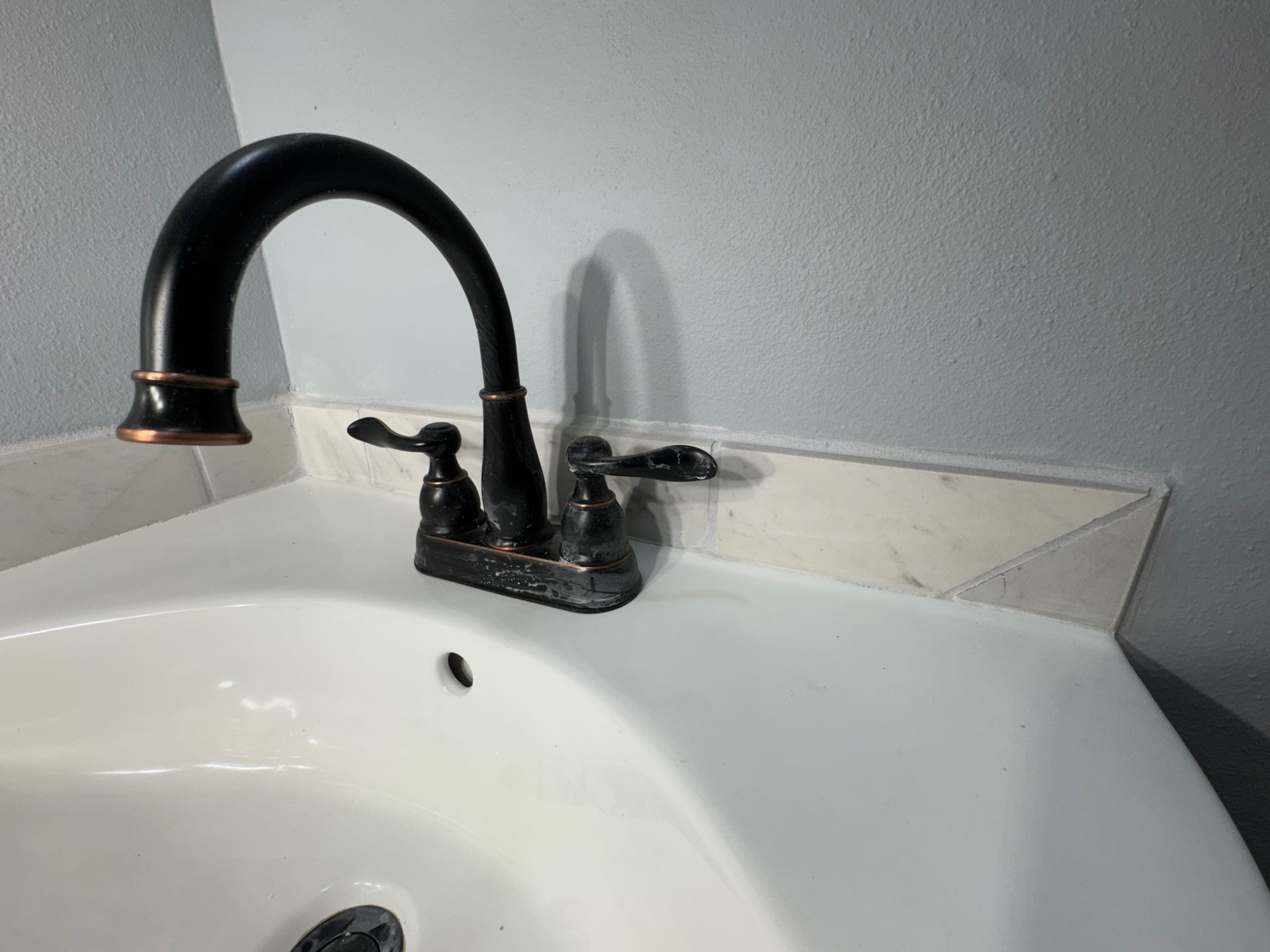 A bathroom sink with a black faucet and a white sink