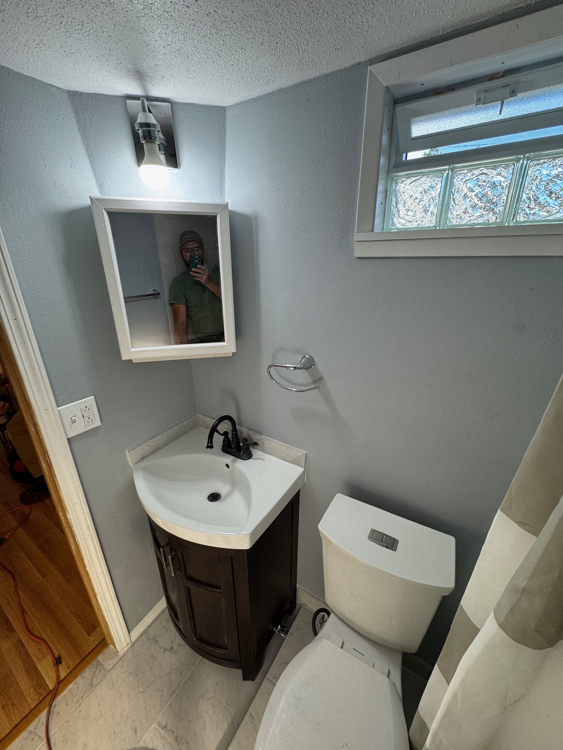 A bathroom with a sink , toilet and mirror.
