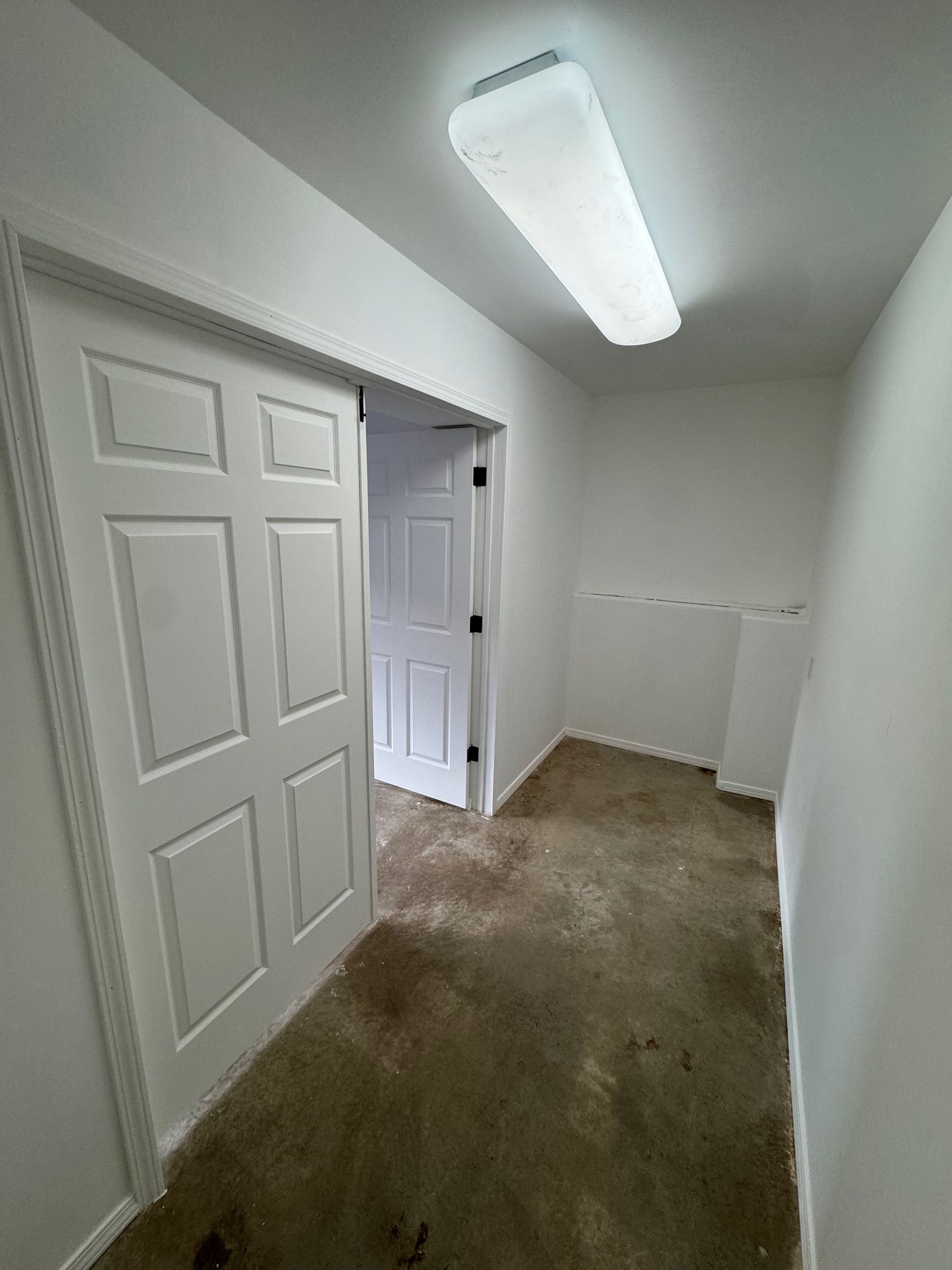 A hallway with a sliding door and a light on the ceiling.