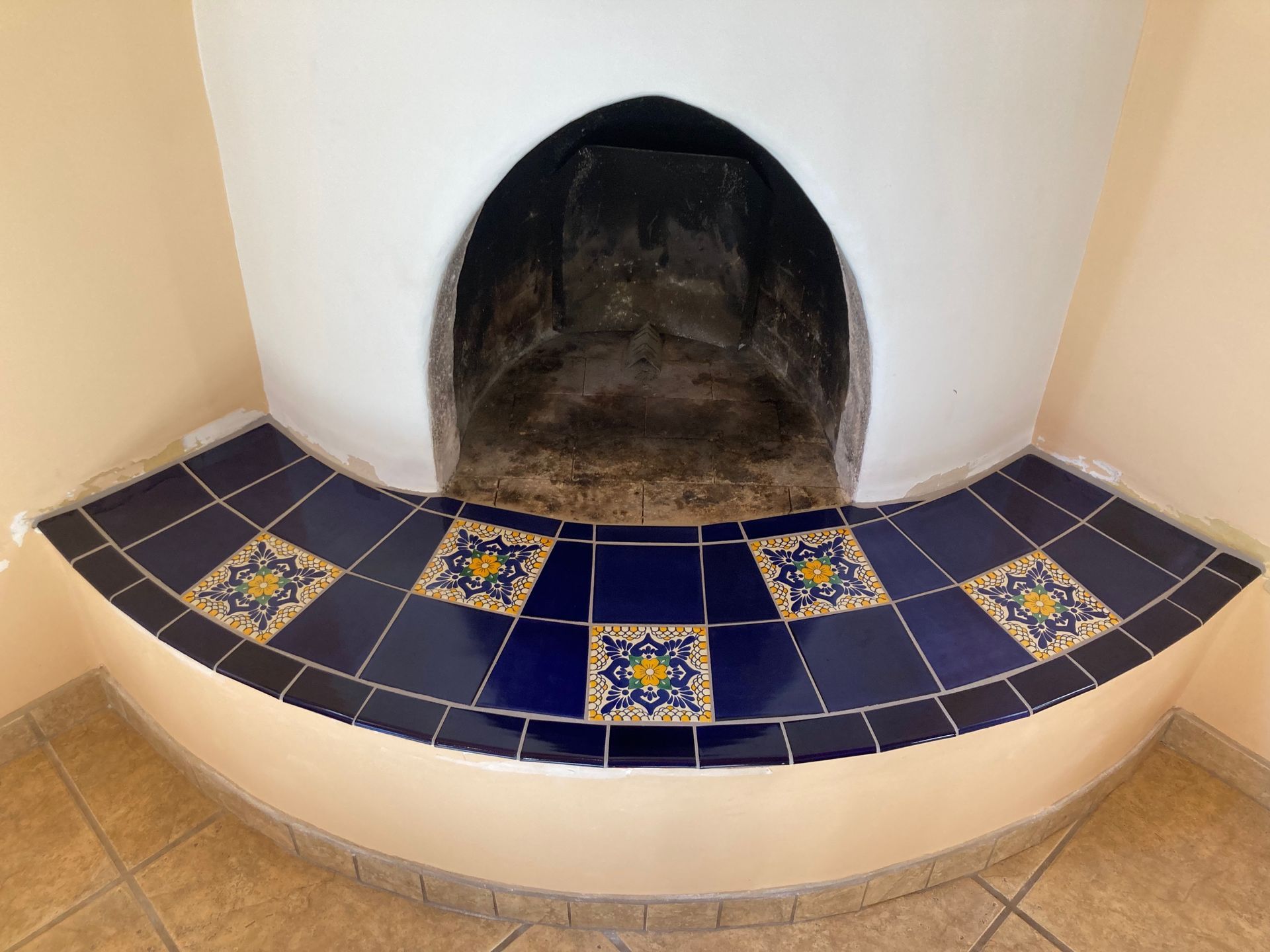A fireplace with blue and yellow tiles around it