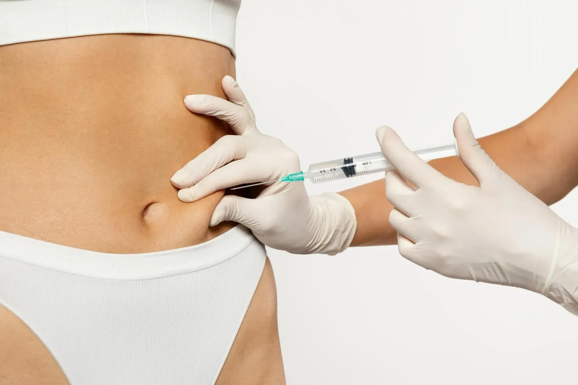 A woman is getting an injection in her stomach.