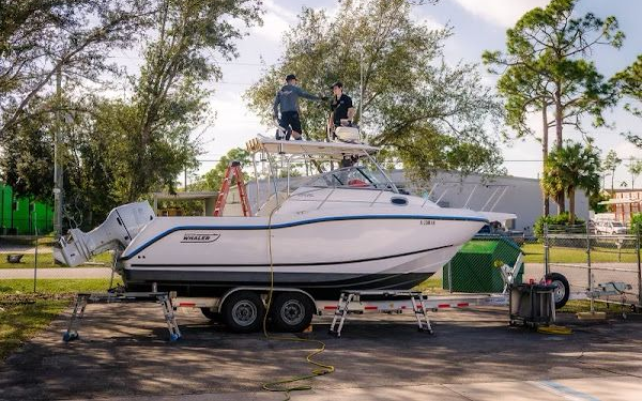 Two men are working on a boat on a trailer.